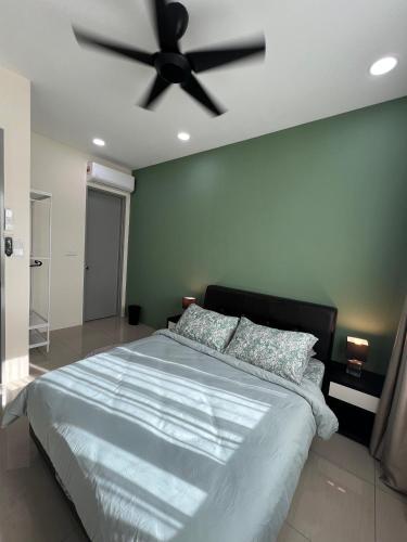 a bedroom with a large bed with a ceiling fan at Cozy Modern Condo with Pool & City Access in Bayan Lepas