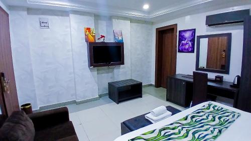 a room with a bed and a tv on a wall at AA Hotels Abuja in Abuja