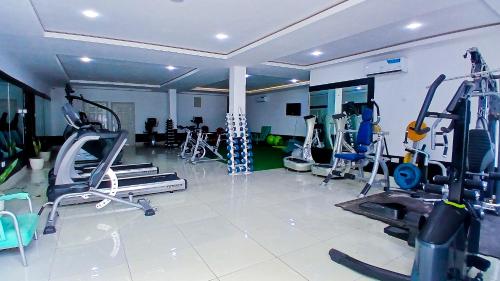 a gym with several tread machines in a room at AA Hotels Abuja in Abuja