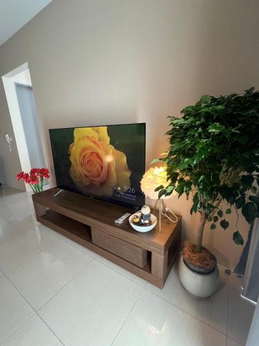 a living room with a tv with a flower on the screen at Cozy Modern Condo with Pool & City Access in Bayan Lepas