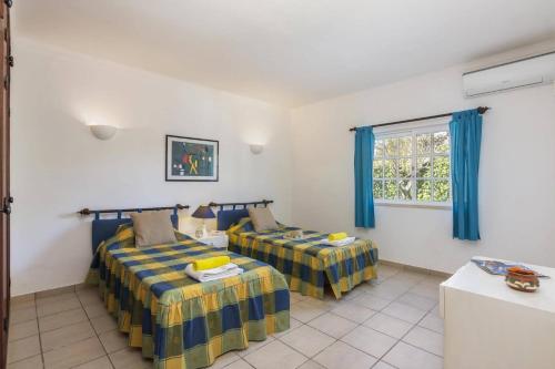 una stanza con due letti e una finestra di Villa Colina do Sol by Villa Plus a Paderne