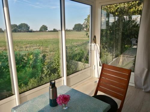 a room with a table and a view of a field at Gîte Bouconne in Pibrac
