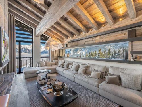 salon z kanapą i stołem w obiekcie Chalet luxueux à Courchevel avec piscine, cinéma, salle de sport et service complet - FR-1-562-71 w Courchevel