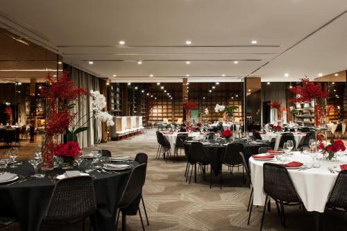 a banquet hall with tables and chairs with red flowers at Ovolo Woolloomooloo in Sydney