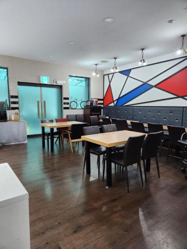 a room with tables and chairs and a painting on the wall at Central Plaza Hotel in Seryu-dong