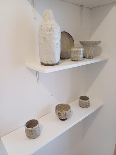 a shelf with bowls and vases on it at Bistra in Ajdovščina