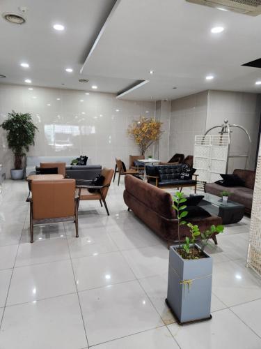 a living room with couches and tables and plants at Central Plaza Hotel in Seryu-dong