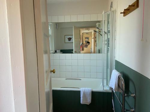 a bathroom with a bath tub and a mirror at Kirkmay 4 in Crail