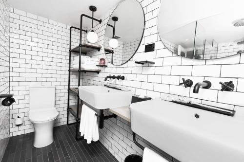 a bathroom with a sink and a toilet and a mirror at Ovolo Woolloomooloo in Sydney