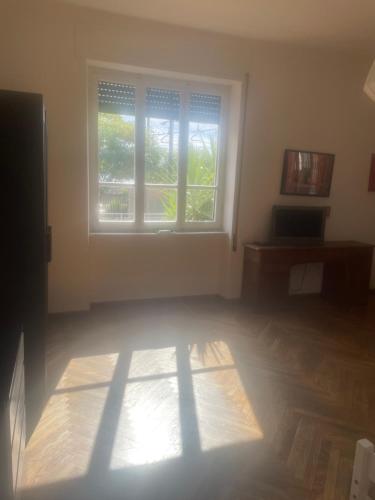 an empty room with a large window in a room at casa ibisco-50m dal mare in Bordighera