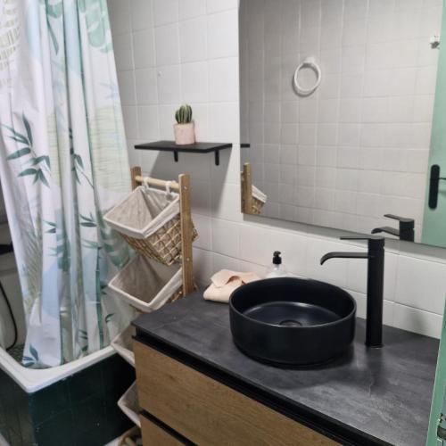 a bathroom with a black sink and a mirror at RentitSpain Ático en primera línea de playa Terraza y piscina in Salobreña