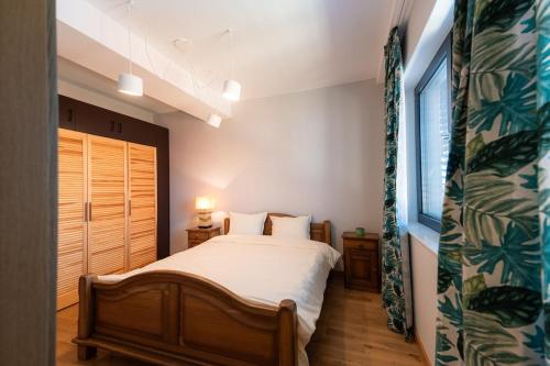 a bedroom with a bed and a window at Къща за гости "Фамилия" in Raduil
