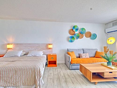 a bedroom with a bed and a couch at Studio spacieux à Baie Orientale avec piscine et parking - FR-1-734-31 in Cul de Sac
