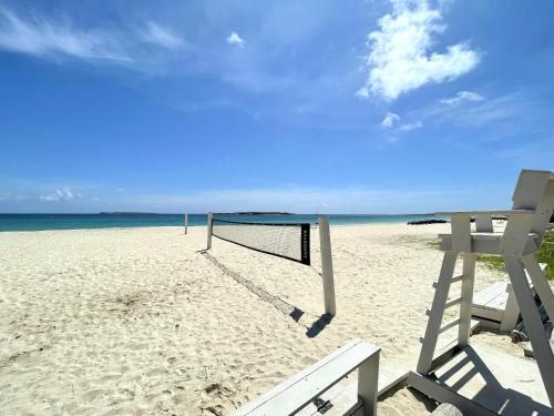 a volleyball net on a sandy beach with the ocean at Studio spacieux à Baie Orientale avec piscine et parking - FR-1-734-31 in Cul de Sac