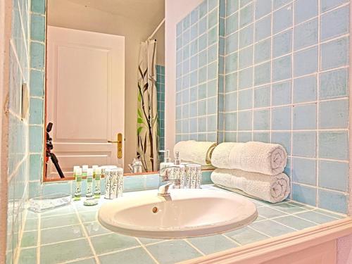a bathroom with a sink and a mirror and towels at Charmante Villa "Coquelicot" à Orient Baie, Proche Plage et Commerces, Confort et Détente Garantis - FR-1-734-10 in Orient Bay