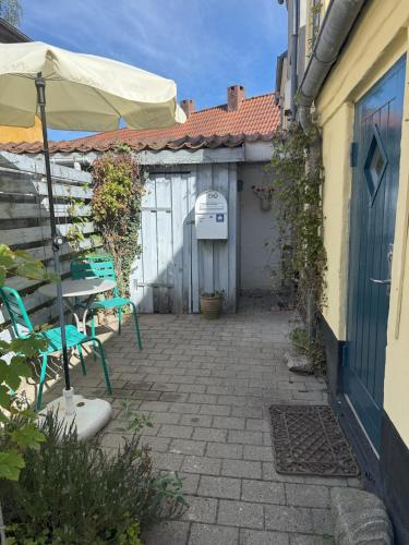 a patio with an umbrella and a table and chairs at Historical Townhouse in Aabenraa