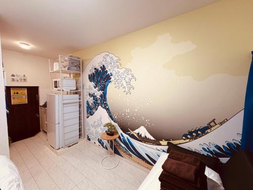 a room with a painting of a wave on the wall at LEON RESORT HOTEL B 4rooms MAX14people 6min Shinjuku 11min Shibuya 12min walk Ikebukuro LEON RESORT IKEBUKURO traditional Japanese room 池袋 最大14名 in Tokyo