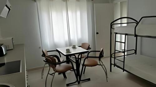 a room with a table and chairs and a bunk bed at Hotel Alda Ribeira in Ribeira