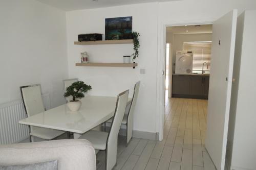 a dining room with a white table and chairs at Comfortable Family Suite For 4 People in Stone Grove