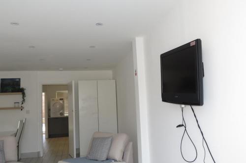 a flat screen tv hanging on a wall in a living room at Comfortable Family Suite For 4 People in Stone Grove