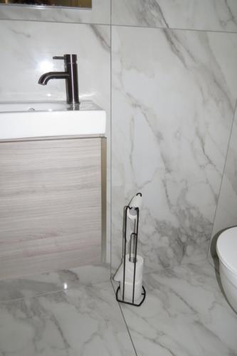a white bathroom with a sink and a toilet at Comfortable Family Suite For 4 People in Stone Grove