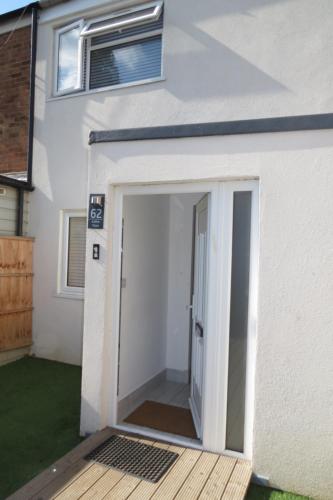 an open garage door on a white house at Comfortable Family Suite For 4 People in Stone Grove