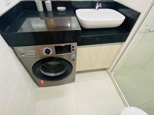 a washing machine in a bathroom with a sink at Studio Unique 2802 com garagem á 15 min do centro de Belém in Belém