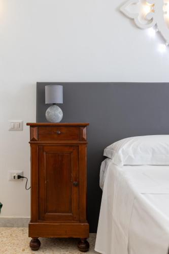 a bedroom with a bed and a night stand with a lamp at B&B Don Alessandro in Surbo