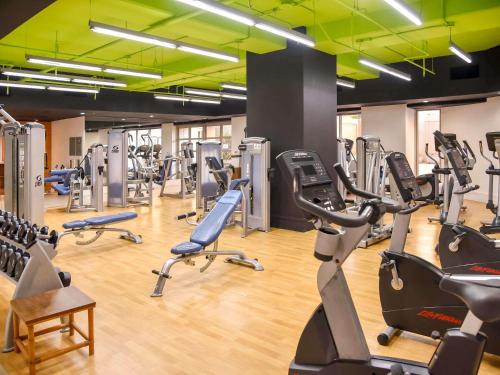 a gym with several treadmills and exercise bikes at Ala Moana Honolulu by Mantra in Honolulu
