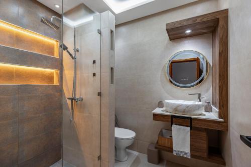 a bathroom with a sink and a toilet and a mirror at Harhoura Luxury Stay, Steps from the Beach in Temara