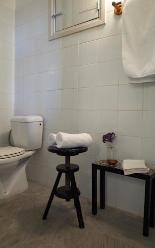 a bathroom with a toilet and a stool next to a table at Ample Places in Pano Lefkara