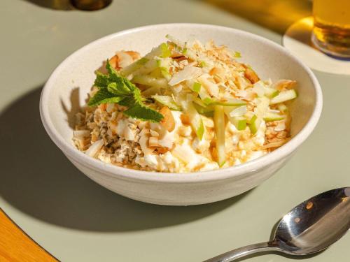 a bowl of food on a table with a spoon at Mantra South Bank Brisbane in Brisbane