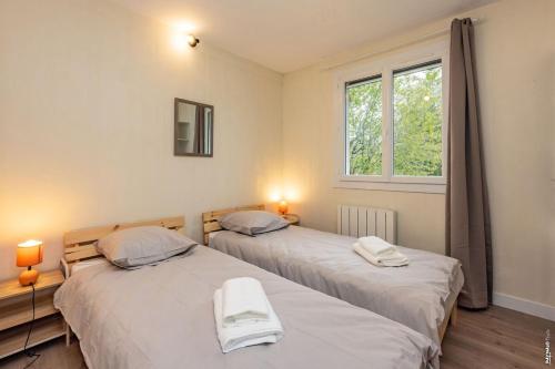 two beds sitting next to each other in a room at La pause en Grésigne - Calme - Nature in Castelnau-de-Montmiral