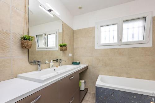 a bathroom with a sink and a mirror and a tub at La pause en Grésigne - Calme - Nature in Castelnau-de-Montmiral