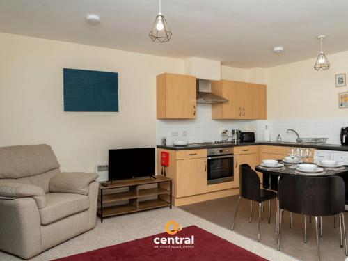 a kitchen and living room with a couch and a table at Bellfield by CENTRAL SERVICED APARTMENTS - Walk away from Dundee University - 2 Bedrooms - 2 Bathrooms - 2 King Beds - Smart TVs - Fully Equipped - Parking - Close to City Centre in Dundee