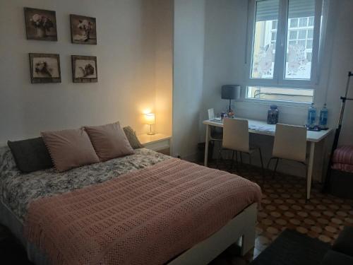 a bedroom with a bed and a desk and a window at Apartamento Frida se alquila por habitaciones in A Coruña