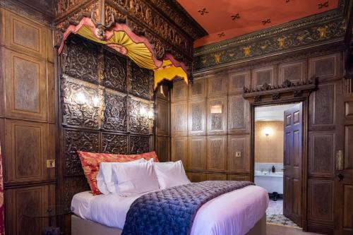 Un dormitorio con una cama en una habitación con paredes de madera. en Salem The Blue Chapel, en Llwyngwril