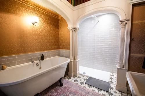 Un baño con bañera y ventana. en Salem The Blue Chapel, en Llwyngwril