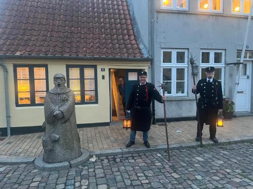 a couple of men in uniform standing next to a statue at Historical Townhouse in Aabenraa