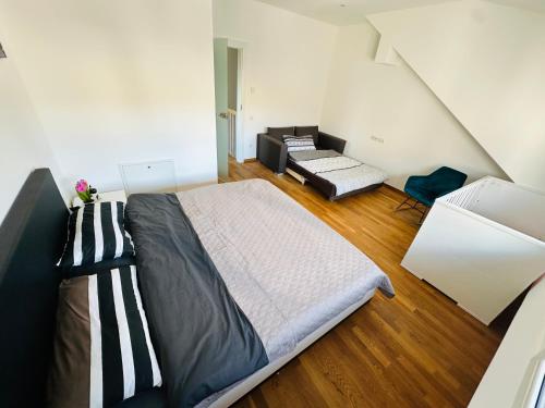 a bedroom with a large bed and a couch at Große 2 Ferienwohnung Gästehaus NEUBAU Merzig 100 m2 in Merzig