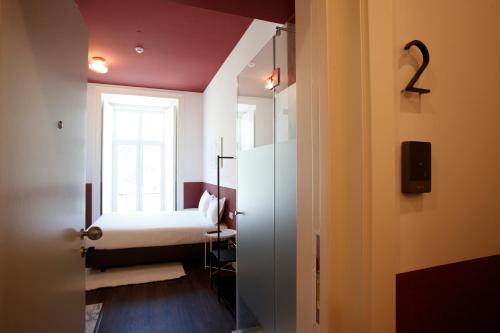 a small room with a bed and a window at Gloria Guesthouse in Lisbon