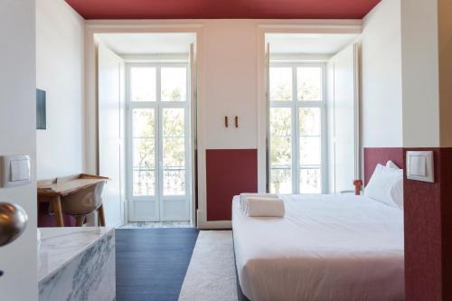 a bedroom with a bed and a bathroom with a sink at Gloria Guesthouse in Lisbon