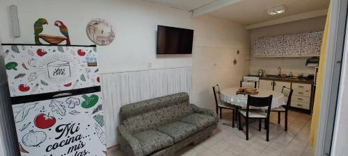 a living room with a couch and a table in a kitchen at Altos 679inn in Comodoro Rivadavia