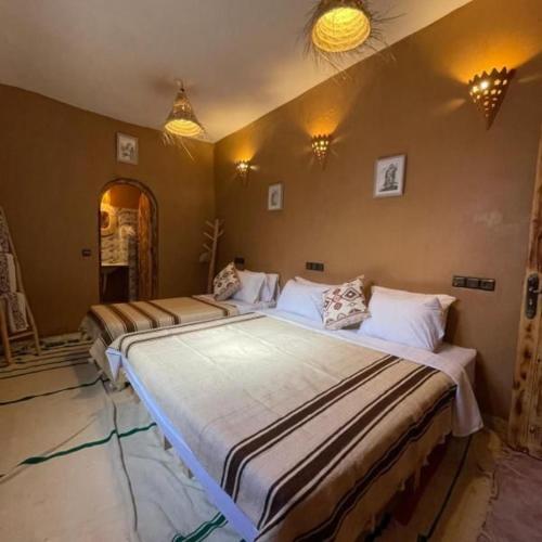 a bedroom with three beds in a room at Casa de las Estrellas in Mhamid