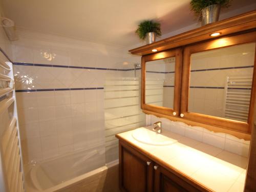 a bathroom with a sink and a tub and a mirror at Les Saisies: 3 pièces cosy, 2 sdb, balcon, parking, 6 pers - FR-1-293-78 in Villard-sur-Doron