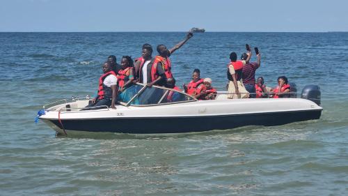 a group of people on a boat in the water at Bugoma Palms Resort Sand Beach 