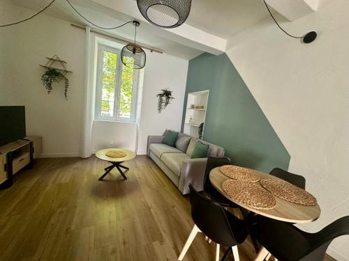 a living room with a couch and a table at La suite-Appartement Cosy 300m du théâtre Antique in Orange