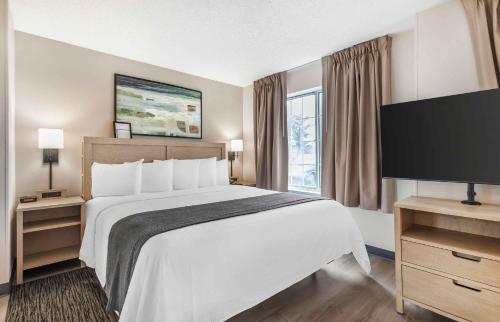 a hotel room with a large bed and a television at Extended Stay America Suites - Washington, DC - Alexandria - Eisenhower Ave in Alexandria