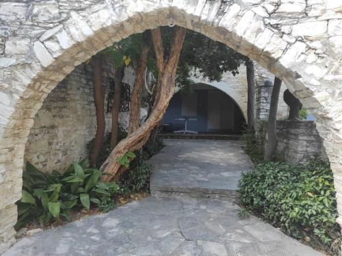 an archway in a stone building with trees in it at Ample Places in Pano Lefkara