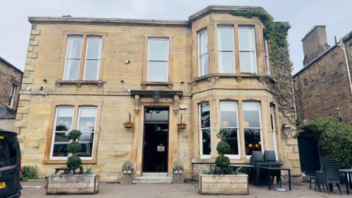 a building with a table and chairs in front of it at Edinburgh Whisky House Hotel in Edinburgh